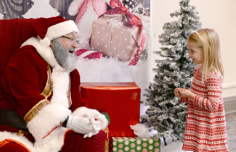 Jill Schultz of Arlington Heights tells Santa what she wants for Christmas during the Downers Grove Park District's Candy Cane Lane event Saturday, Dec. 2, 2023.