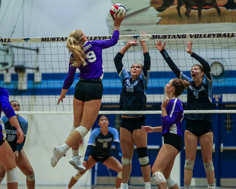 Downer Grove North's Avery Presern (19) tips the ball over the net during volleyball match between Downers Grove North at Downers Grove South.  Sept 7, 2023.