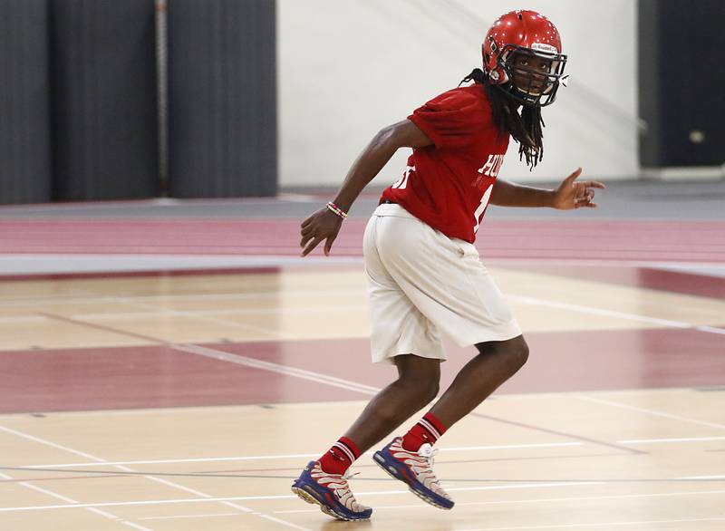 Huntley’s Dashaun Manning runs a defensive drill during the first day of football practice Monday, 8, 2022, in the Huntley High School  field house after stormy weather move practice inside.