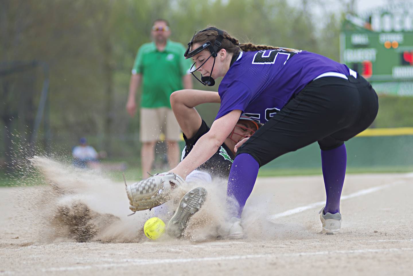 Rock Falls' Taylor Reyna slides in safely at home against Dixon's Ellie Jarrett on May 10, 2022.
