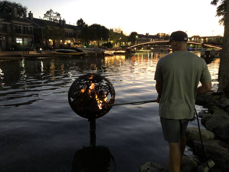 A McHenry Parks and Recreation worker used a flame thrower to light on of the 15 fire globes on Saturday, Sept. 27, 2025, for McHenry's annual Light the Night at Miller Point Park.