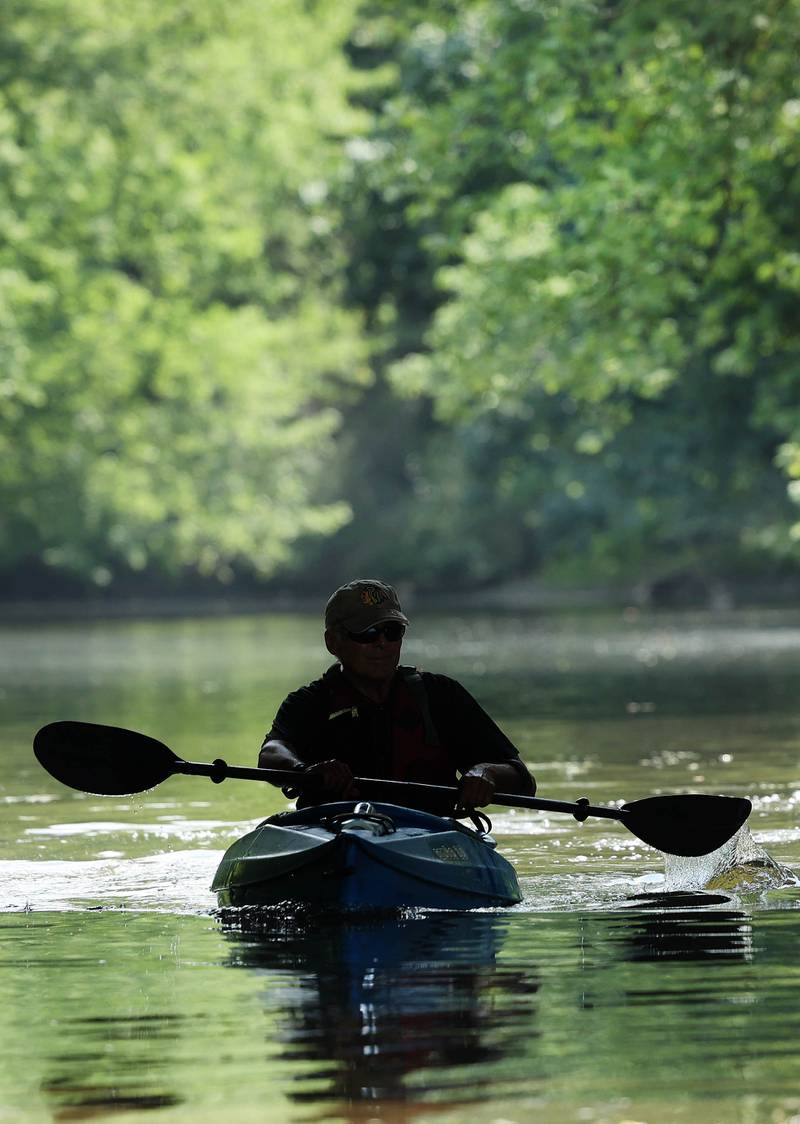 Greg Romaneck kayaks under the Base Line Road bridge Thursday, Aug. 10, 2023, in the Kishwaukee River near the Knute Olson, Jr. Forest Preserve in Kingston. Romaneck has been making regular visits to pick up trash as he paddles the river and been an advocate for keeping the river and its surroundings free of pollution.