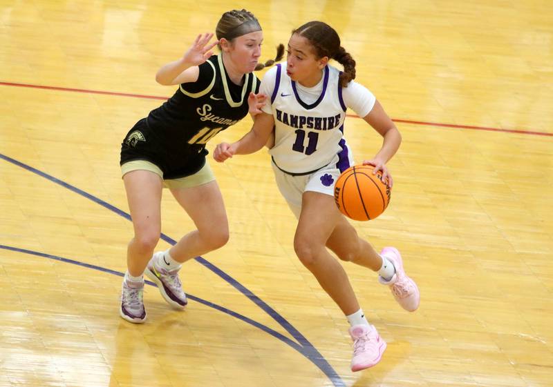 Hampshire’s Mikala Amegasse, right, drives as Sycamore’s Cortni Kruizenga defends in varsity girls basketball on Friday, Jan. 3, 2025, at Hampshire High School in Hampshire.