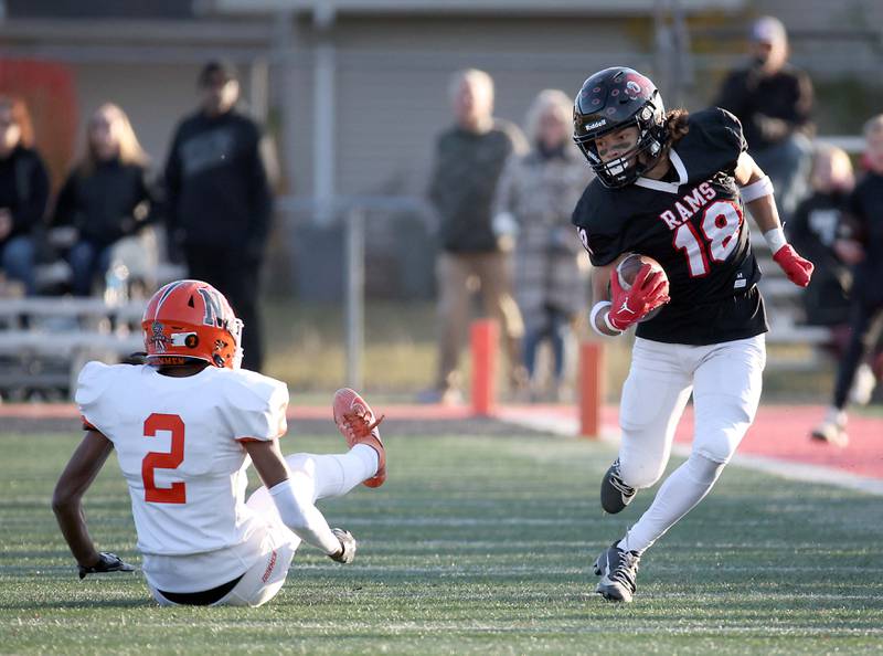 Glenbard East's Chris Renford (18) heads in for a long touchdown after maneuvering past Normal's Jackson Eimer (2) during the IHSA Class 7A quarterfinals Saturday November 11, 2023 in Lombard.