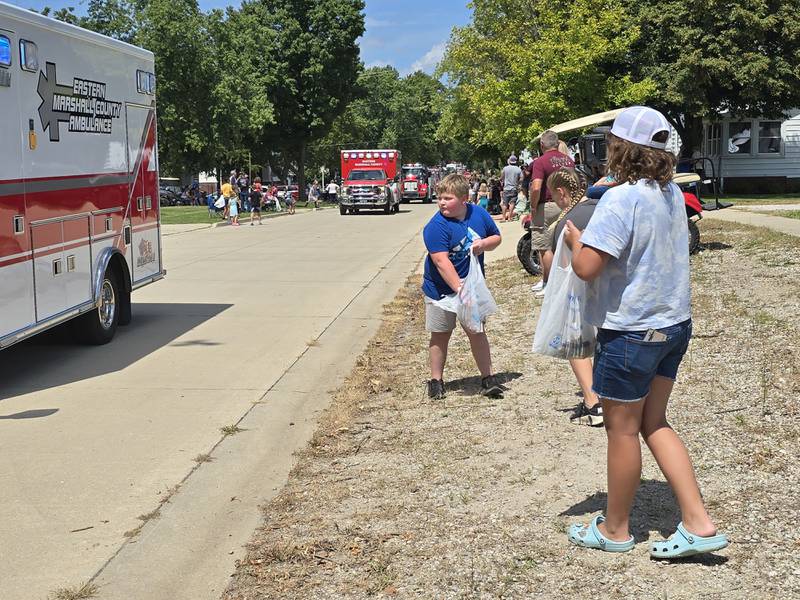 Children parade goers fill their bags with candy Sunday, Aug. 11, 2024, during the Wenona Days Grand Parade.