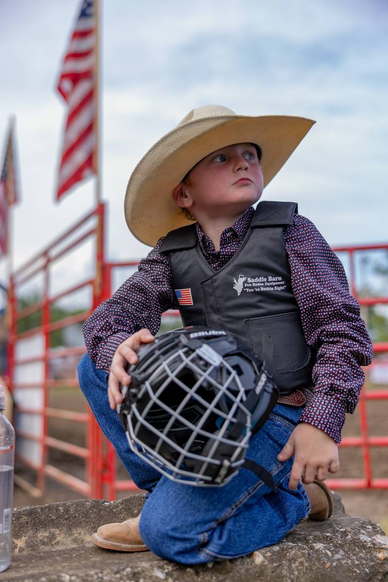 Phoenix Cagle looks to the crowd before riding in the mutton busting competition for kids prior to the start of the LaSalle County 4H Fair rodeo on July 11, 2025 in Ottawa.
