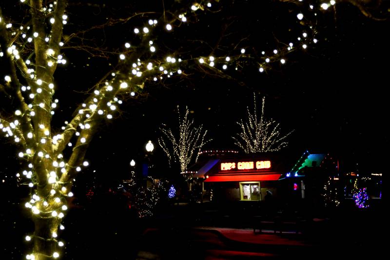 Holiday lights frame Pop’s Corn Crib during Crystal Lake's Luminary Nights on Thursday, Dec. 19, 2024, in downtown Crystal Lake. The snowy night featured sidewalks lite luminaries, holiday shopping and a visit to the Santa House.