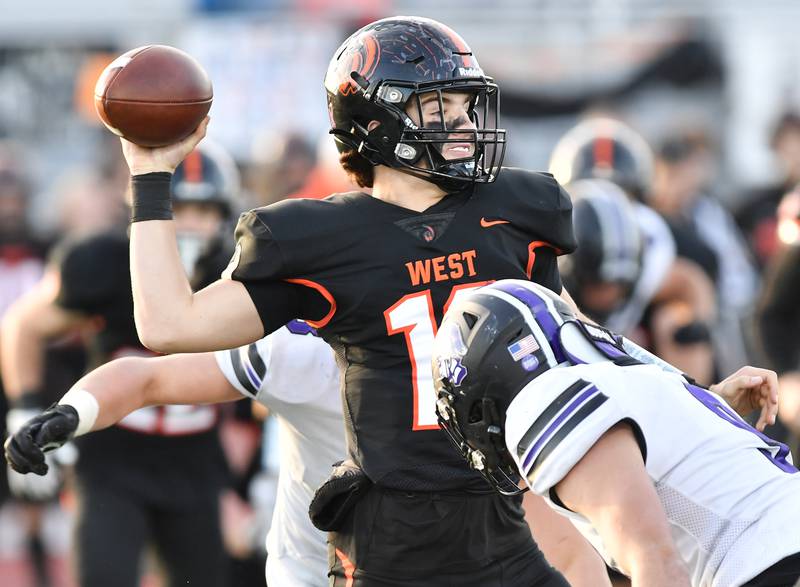 Lincoln-Way West quarterback Chase Hetfleisch fires a pass under heavy pressure from Downers Grove North defenders during an IHSA Class 7A quarterfinal game on Nov. 11, 2023 at Lincoln-Way West High School in New Lenox.