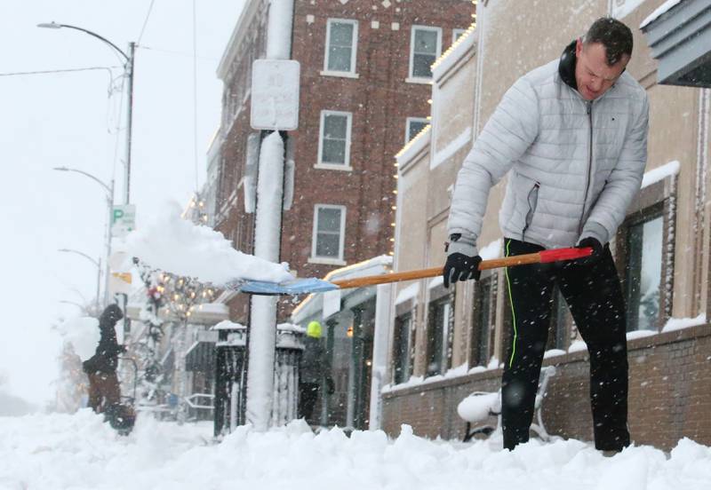 Levi LaMothe, owner of Anytime Fitness shovels snow off the sidewalk in front of his business on Tuesday, Jan. 9, 2024 downtown Princeton.