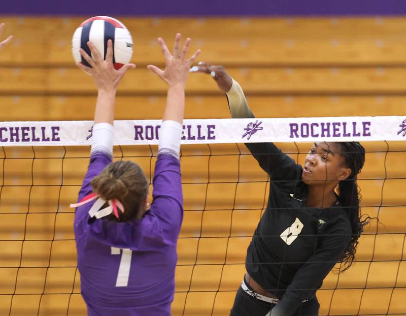 Sycamore's Khiara Thomas spikes the ball by Rochelle's Meredith Bruns Tuesday, Oct. 28, 2025, during their Class 3A regional semifinal match at Rochelle High School.