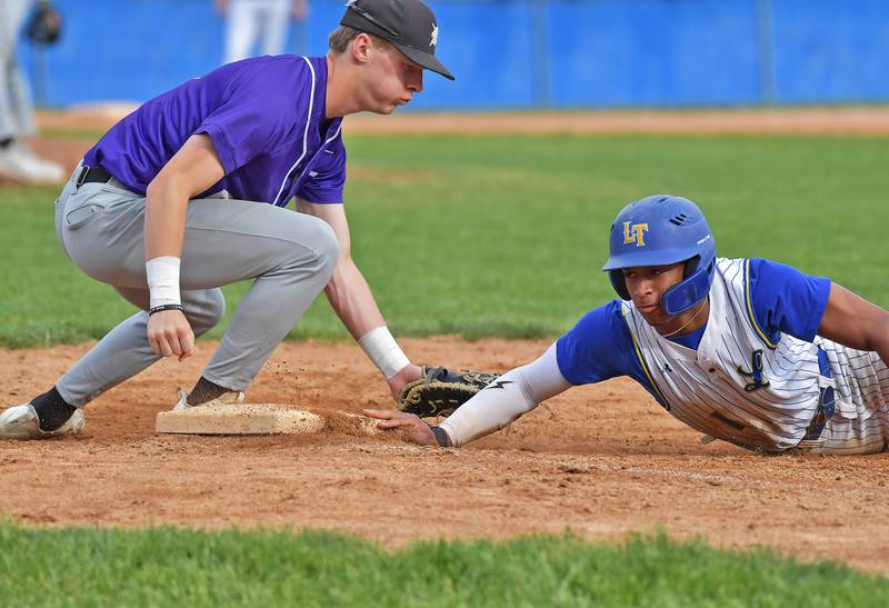 Lyons Township’s Blake Ragsdale dives safely back to first base as Downers Grove North’s Jack Romsey reaches to tag during a game on May 18, 2026 at Lyons Township High School in LaGrange.