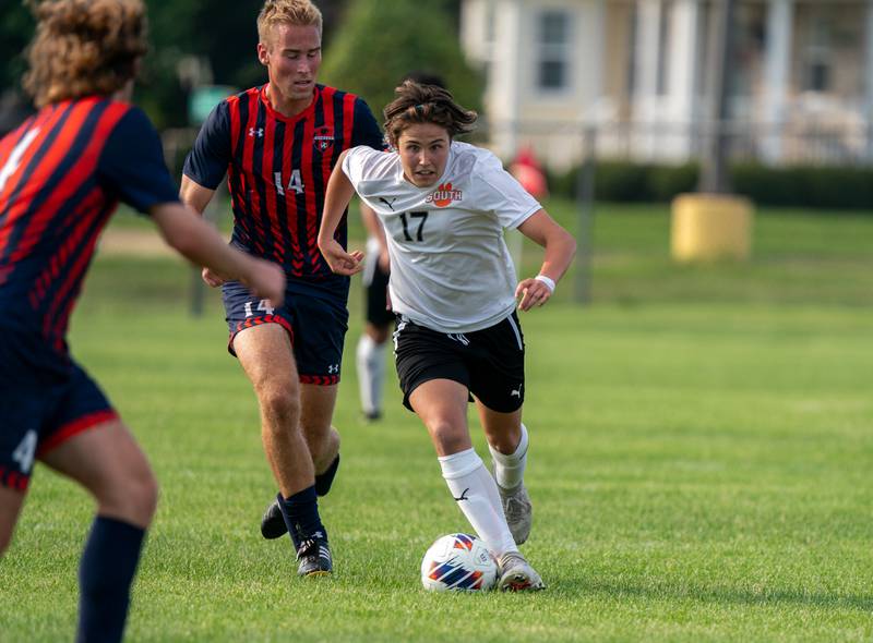 Wheaton Warrenville South's Robert Redlich (17) plays the ball against Oswego’s William Kalsto (14) during a soccer match at Oswego High School on Thursday, Aug 25, 2022.