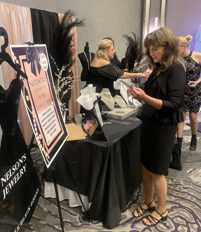 Georgette Santucci of Crystal Lake looks over a raffle hosted by Nelson’s Jewelry at CASA of McHenry County's Little Black Dress event Oct. 10, 2024.
