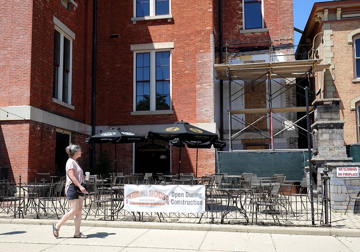 A person walks past the Public House on Thursday, June 16, 2022, in Woodstock. Construction on Dean Street and the new roundabout at the intersection of South Street, Madison Street and Lake Avenue has created issues for some local businesses. A few businesses, particularly on the Square, are worried about the effect the work will have on their business this year and next year.