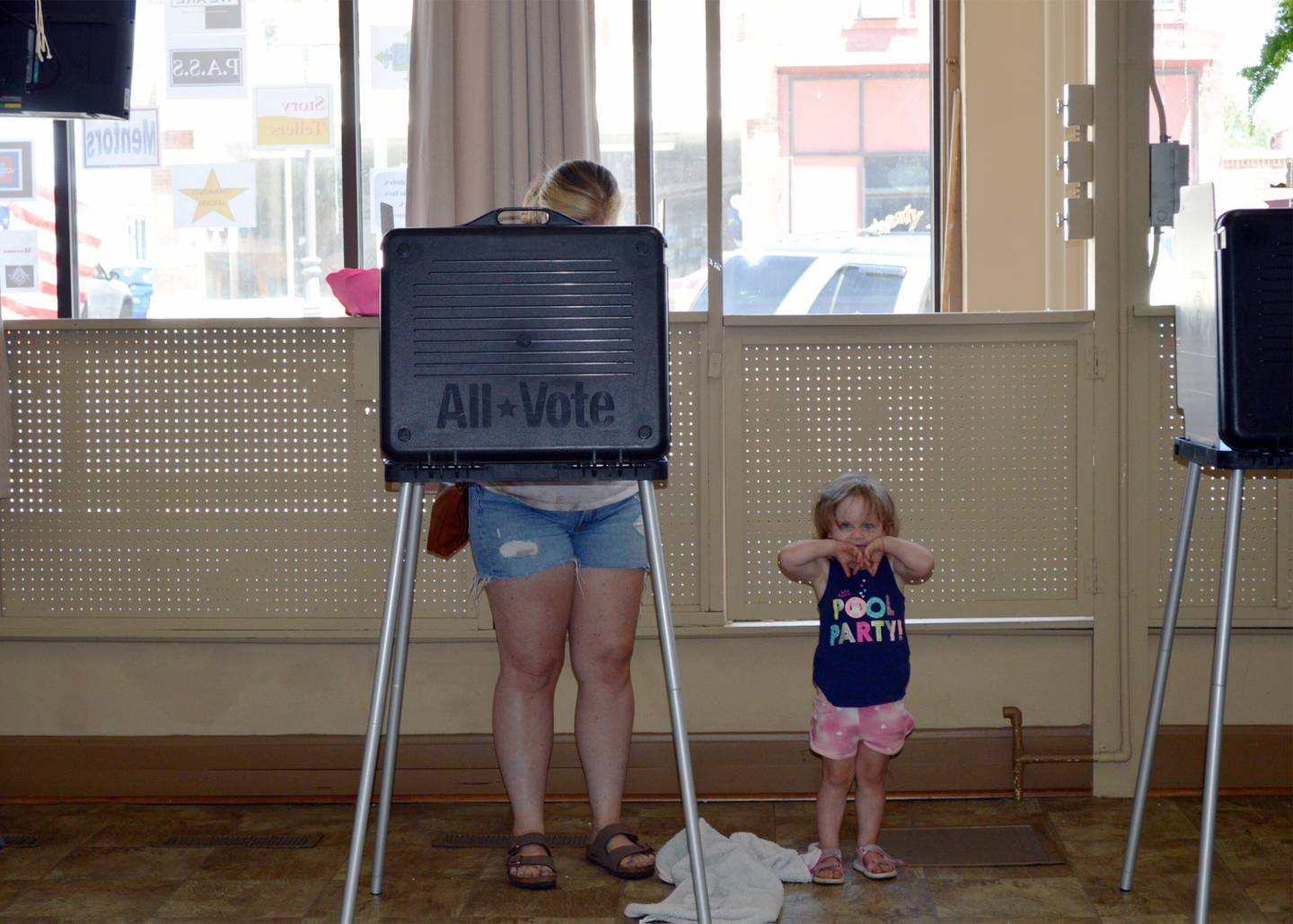 Emry Hollewell, 1, stays nearby as her mother, Katie Hollewell, votes in the June 28 primary election. Hollewell cast her ballot at the Polo Area Senior Services Center in downtown Polo.