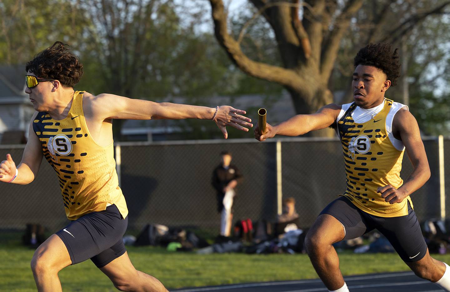 Joseph Holcomb reaches back for the baton from Kaeden Phillips in the 4x100 Thursday, April 25, 2024 at the Sterling High School Night Relays.