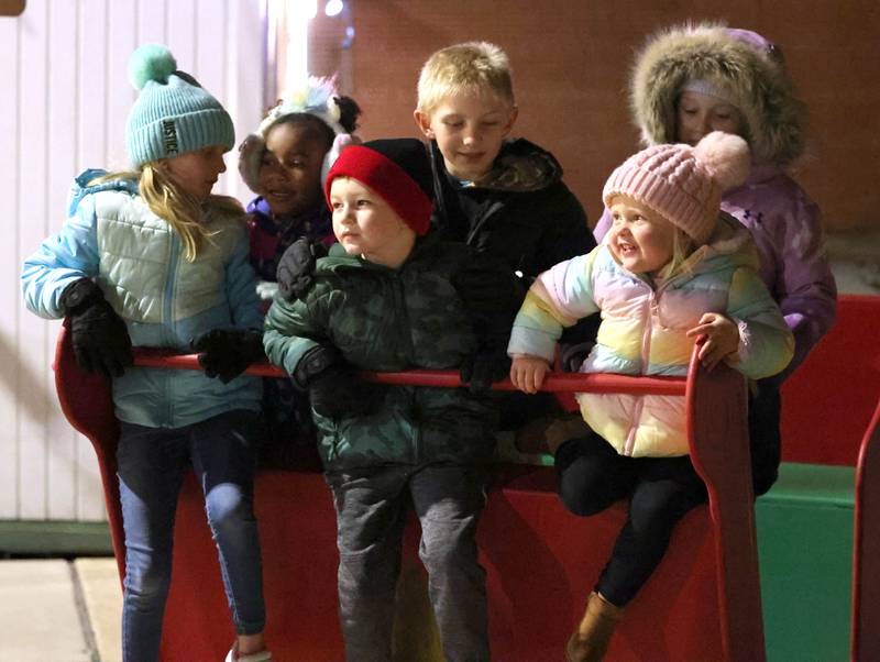 Kids play on the sleigh by the Santa house as they wait for his arrival Friday, Dec. 2, 2022, during Celebrate the Season hosted by the Genoa Area Chamber of Commerce.