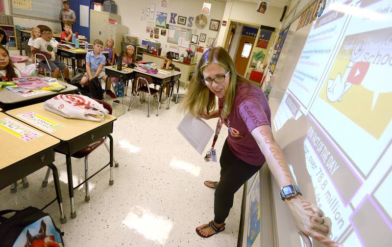 Second grade teacher Kim Siok introduces her students to the day's lunch menu on the first day of school at Grande Reserve Elementary in Yorkville on Thursday, Aug. 24, 2023.