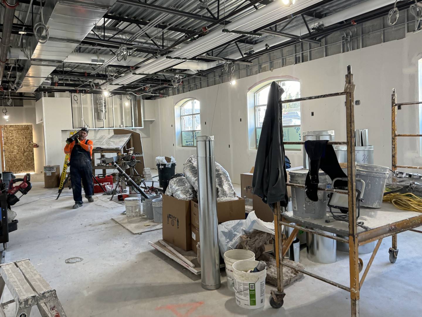 A construction worker carries material to continue his work inside the new Morris fire station.
