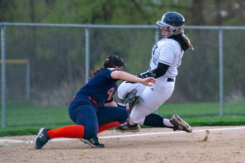 Oswego’s Rikka Ludvigson (left) tags Oswego East's Tristin Hyland for an out during a softball game at Oswego East High School on Wednesday, April 19, 2023.
