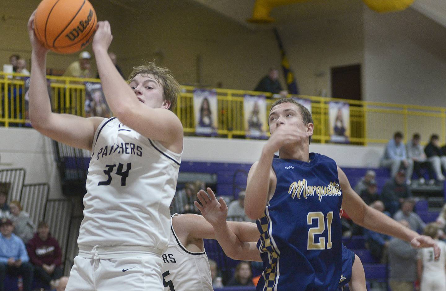 Erie-Prophetstown’s Derek Naftzger pulls down this rebound ahead of Marquette’s Lucas Craig in the fourth period Monday at the Huskers Hardwood Tip-Off Tournament at Serena.
