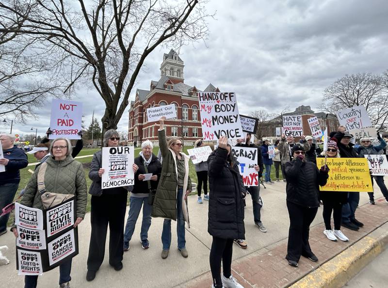 People with signs stand on one of the sidewalks surrounding the historic Ogle County Courthouse in Oregon during a Hands Off rally on Saturday, April 5, 2025. Around 400 people attended the event. Similar rallies were held across the United States for people wanting to speak out about recent actions and decisions by President Donald Trump. The event in Ogle County was organized by Indivisible of Ogle County.
