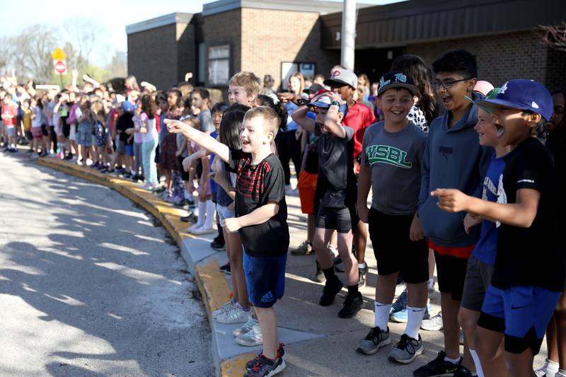 Students at Belle Aire Elementary School in Downers Grove yell as a fire truck, with sirens and lights, pulls up to the school carrying third-grader Kyla Richardson and her first-grade sister, Laina. Kyla won the trip by entering a contest sponsored by the  Fire Department as part of the Learn Not to Burn program.