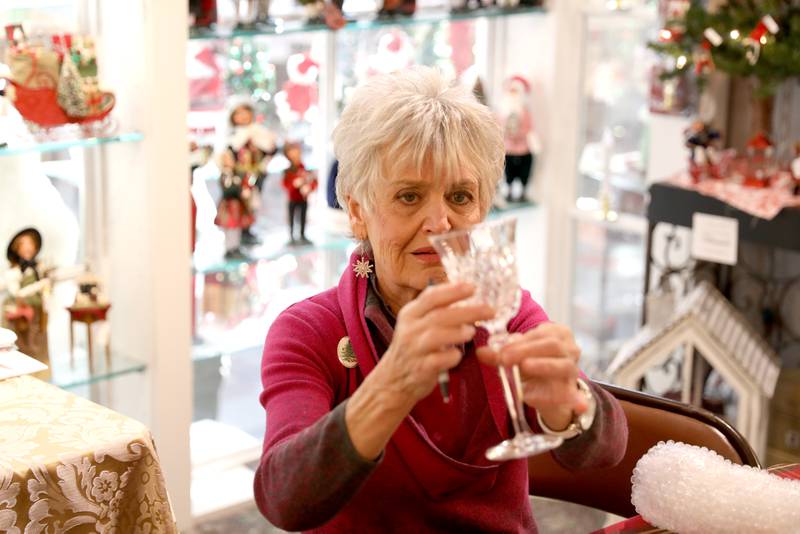 Mary Lou Gates of Mary Lou’s Crystal Repair checks out damaged goblet during a visit to The Little Traveler in Geneva on Wednesday, Nov. 15, 2023.