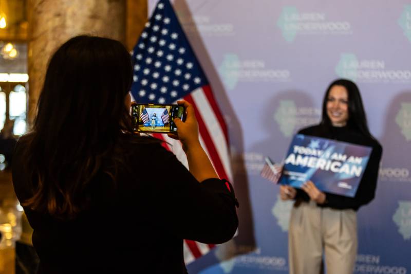 New U.S. citizen Doina Aman Awara gets a photo taken following the Naturalization Ceremony at Rialto Square Theatre in Joliet on April 17, 2025.