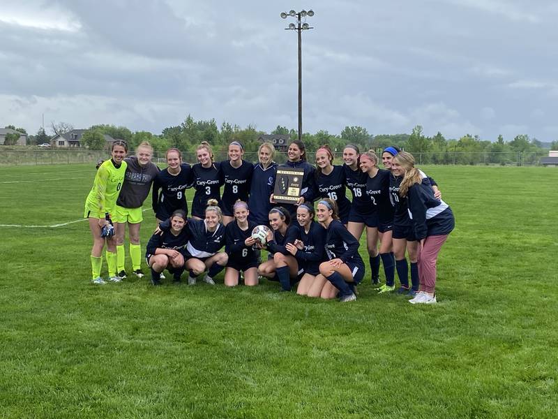 Cary-Grove players pose with their Class 2A Burlington Central Regional championship plaque on Saturday.