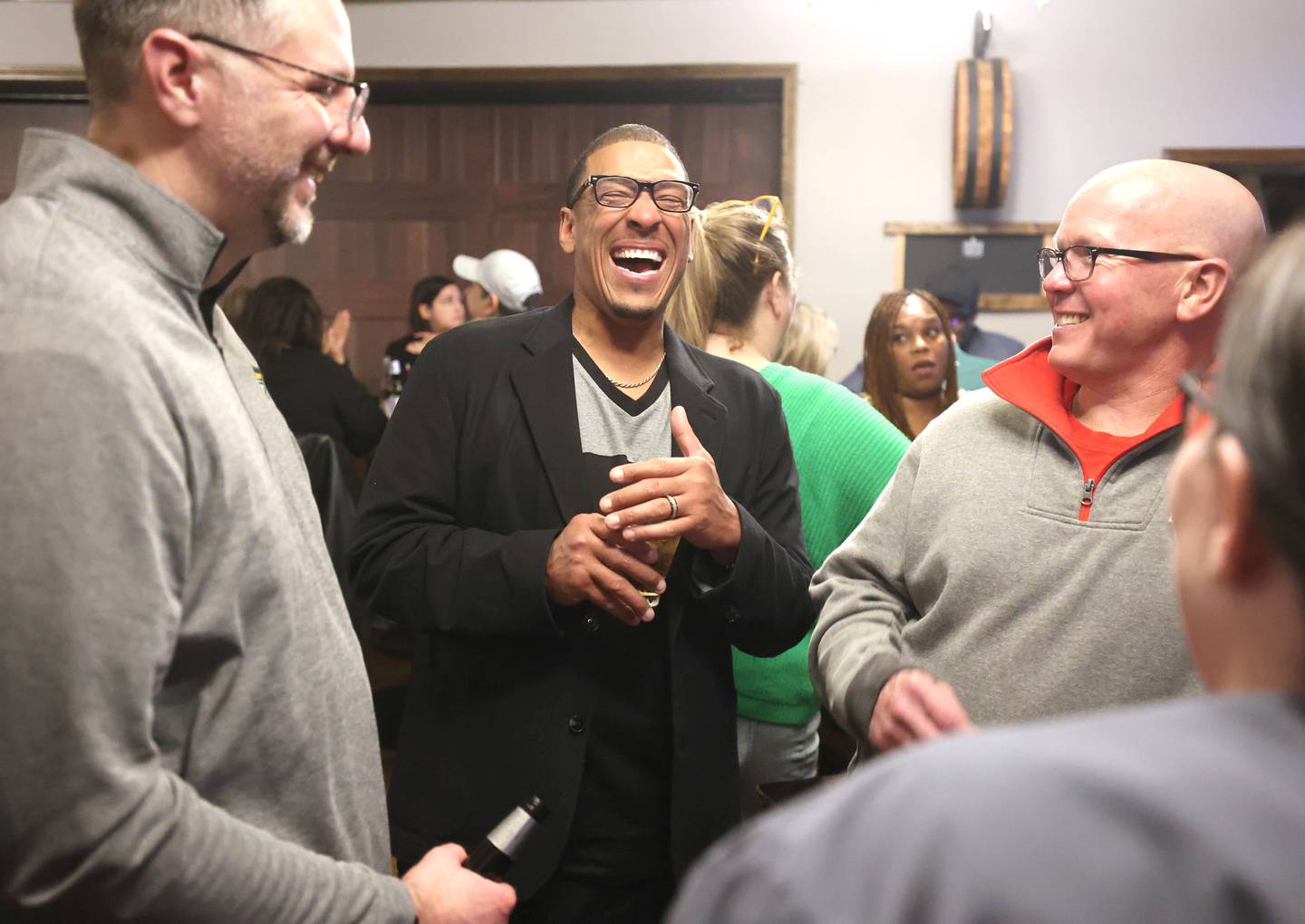 John Walker, (milieu) DeKalb 7th Ward aldermanic candidat, s'amuse avec ses partisans le mardi 4 avril 2023, lors d'une soirée électorale au Fatty's Pub & Grill à DeKalb.