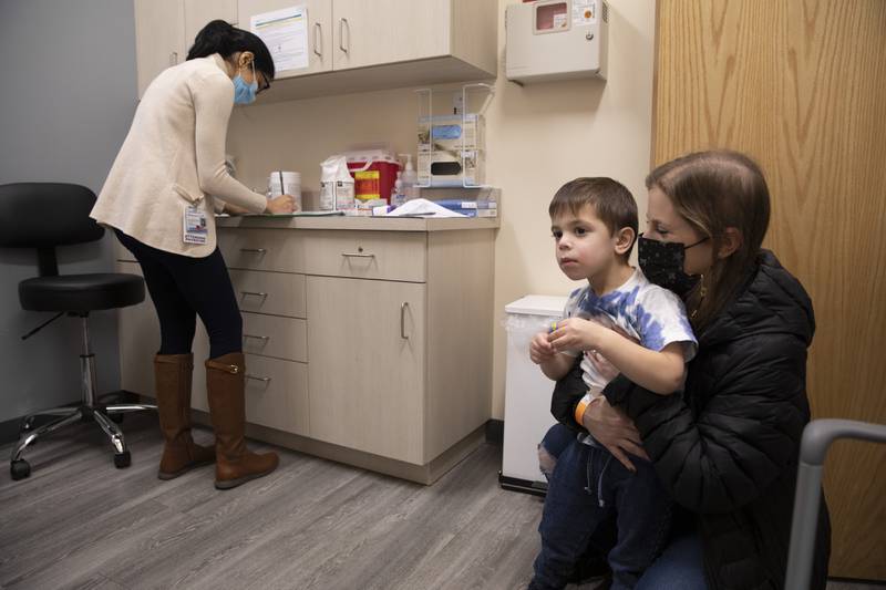 FILE - Ilana Diener holds her son, Hudson, 3, during an appointment for a Moderna COVID-19 vaccine trial in Commack, N.Y. on Nov. 30, 2021. Parents hoping to get their youngest children vaccinated against COVID-19 have some encouraging news. Pfizer said Monday, May 23, 2022, that three doses of its vaccines offers strong protection to those under 5. That news comes a month after Moderna said it would ask regulators to OK its two shot regimen for the youngest kids. (AP Photo/Emma H. Tobin, File)
