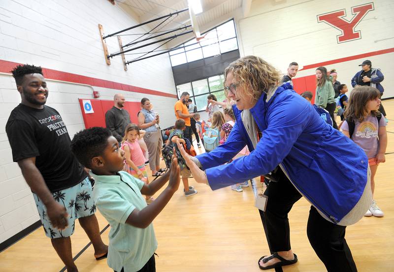 Principal Melinda Hafenrichter greets kindergartener Evan Djoundjeu while Evan’s dad, Hermann, looks on during the first day of classes at Yorkville Grade School on Friday, Aug. 15, 2024.