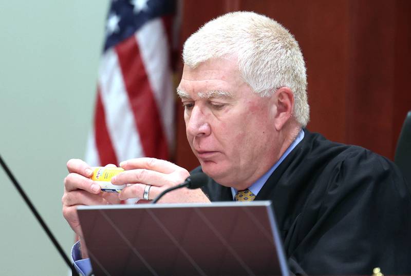 Judge Philip Montgomery looks at the ingredients in a tube of Aspercreme Monday, April 29, 2024, that James Corralejo, of DeKalb, says he used to treat a rash on his leg caused by an ankle bracelet he was ordered to wear to enforce that he not consume alcohol. Prosecutors alleged Corralejo, on release pending charges that he drove drunk and caused a Nov. 5, 2023, crash that killed DeKalb woman Graciela Reza Contreras, 59, tampered with his ankle monitor after it detected alcohol six times in March and April.