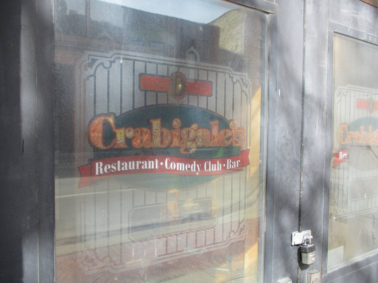 A window at an entrance to the Loughran Building in downtown Joliet serves as a reminder of the Crabigale's comedy club that last occupied the space in 2005. March 10, 2025
