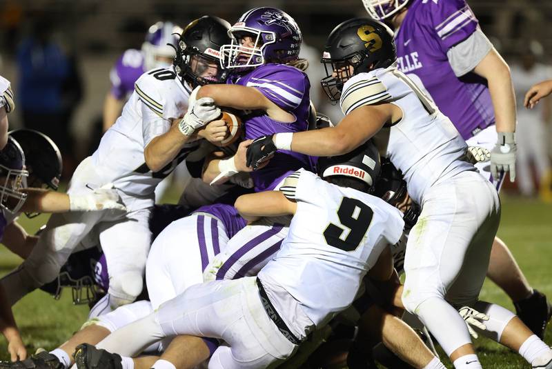The Sycamore defense wraps up Rochelle's Erich Metzger during their game Friday, Sept. 23, 2022, at Rochelle High School.