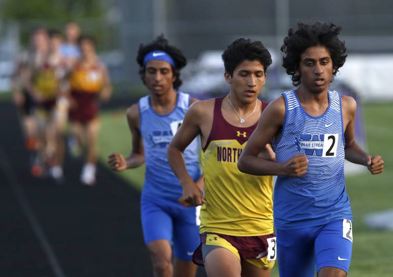 Woodstock’s Aryan Patel, left, and Ishan Patel, right, run on either side of Northridge’s Max Elder as the race in the 1600 meters during the IHSA Class 2A Belvidere  Boys Track and Field Sectional Thursday, May 19, 2022, at Belvidere High School.