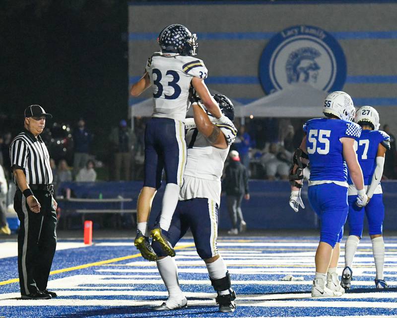 IC Catholic Prep Jackson Ramos, right, lifts up teammate Joey Glatta (33) after scoring a touchdown in the second quarter on Friday Sep. 29, 2023, while traveling to take on St. Francis in Wheaton.