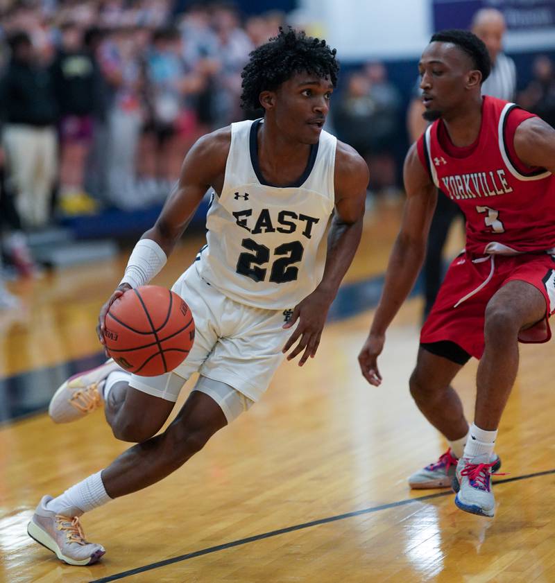 Oswego East's Mason Lockett IV (2) drives to the basket against Yorkville's Dayvion Johnson (3) during a basketball game at Oswego East High School on Friday, Dec 8, 2023.