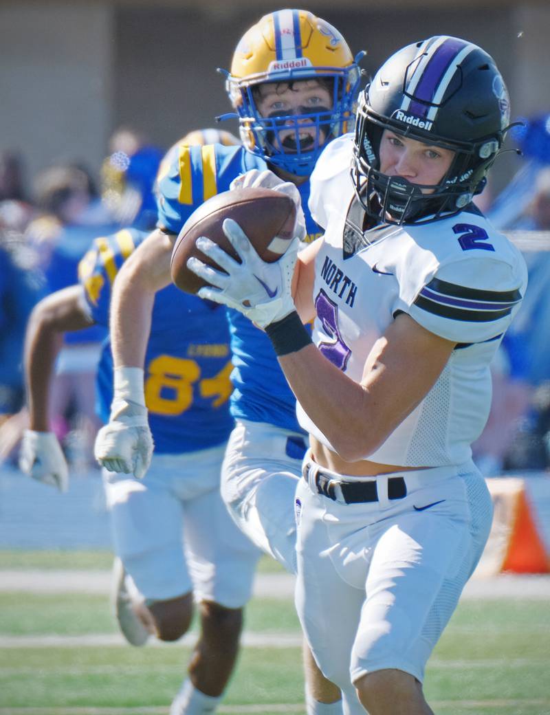 Downers Grove North wide receiver Will Guerin (2) turns his attention to the end zone after making a catch in front of Lyons Township's Quinn Farnan during a game on Oct. 22, 2022 at Lyons Township High School in LaGrange.