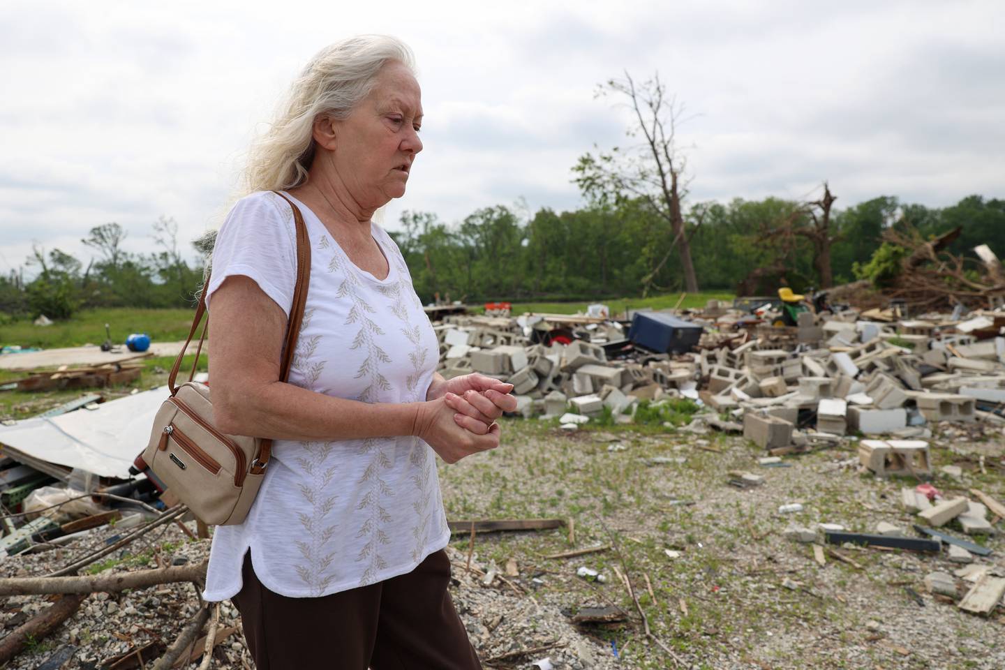 Sue Antonelli recalls the night of the March 10 tornado while standing at the site of her former Sandbar Road home on May 19, 2026, in Aroma Township. Antonelli, who sheltered in the bathroom of the raised home along the Kankakee River, was hospitalized for 22 days with extensive injuries.