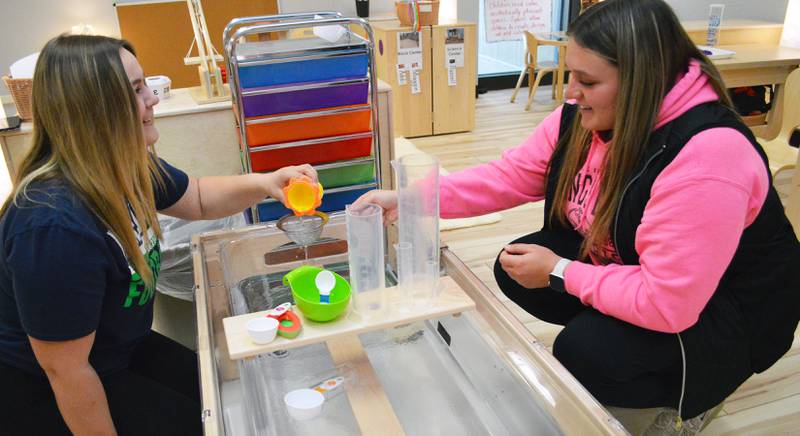Early Childhood Education students Clara Downey (left) and Elizabeth Browder at Illinois Valley Community College explore activities at the Lab’s centerpiece, a water table. Water table activities can promote problem-solving skills, motor skills, creativity, language and understanding of science concepts.