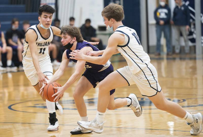 Hampshire's Nicholas Louis tries to get the ball through Cary-Grove defenders Calvin Slimko, left, and Jake Hornok during their game on Tuesday, January 25, 2022 at Cary-Grove High School in Cary.