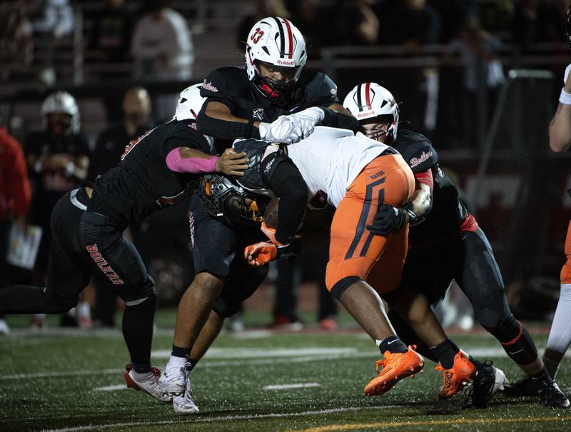 Dekalb's Travis Moore, center, is brought down by a trio of Bradley-Bourbonnais defenders in a game on Friday, October 10, 2025.