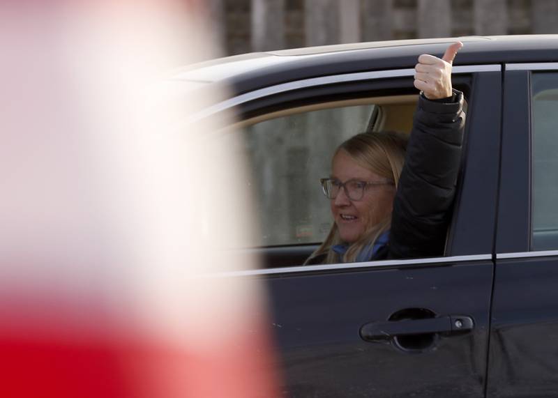 A woman gives a thumbs up as she drives past a Cary School District 26 anti-mask rally Tuesday, Feb. 15, 2022, on Three Oaks Road near Cary-Grove Park. The event was attend by about 100 people and organized by the Illinois Parents Union Cary.