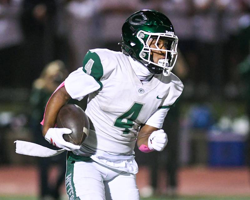 Glenbard West's Jamarcus Kelly (4) runs the ball during the game on Friday Oct. 17, 2025, while traveling to take on York High School.
