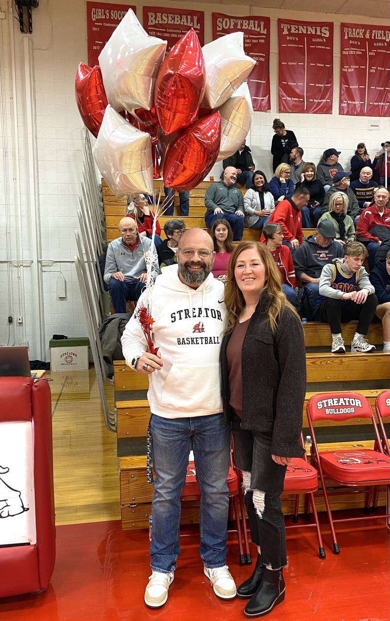 Streator High School assistant principal Nick McGurk stands with his wife, Kathleen McGurk, after being surprised Friday, Jan. 17, 2025, with balloons and the news he has been selected as the Illinois Principals Association's Vice-Principal of the Year for 2025.