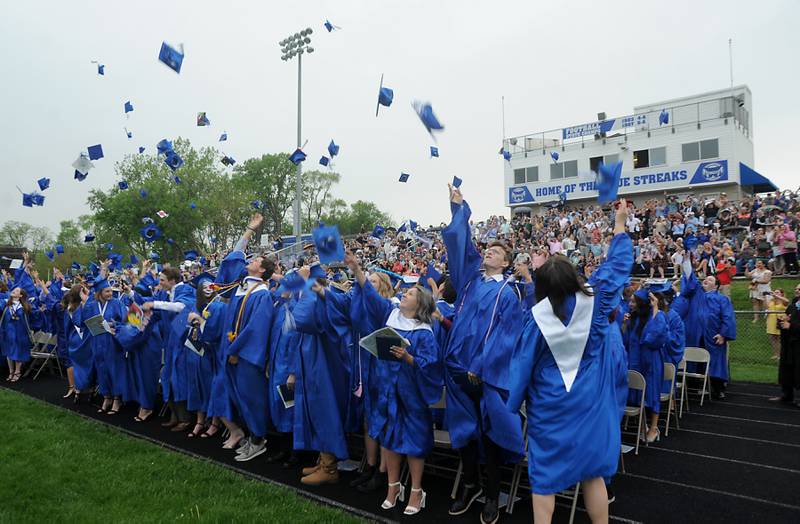 Caps fly as graduates celebrate in the rain Sunday, May 15, 2022, during the Woodstock High School graduation ceremony in Woodstock.