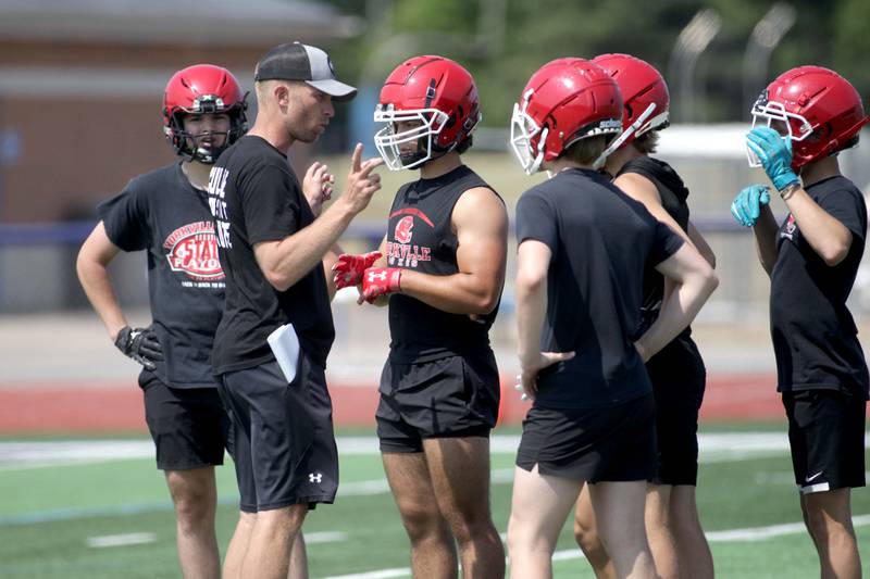 Yorkville Head Coach Dan McGuire talks to some of his team during a 7-on-7 football game against Elk Grove at St. Charles North on Thursday, June 22, 2023.