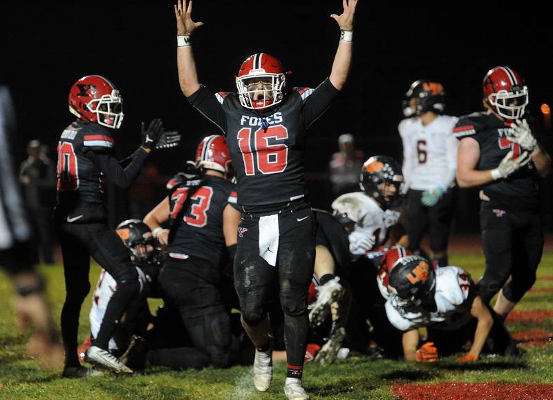 Yorkville quarterback Michael Dopart (16) celebrates a touchdown by running back Gio Zeman who was pushed into the endzone by his entire offensive line against Libertyville during a class 7A playoff football game at Yorkville High School on Friday, Oct. 28, 2022.